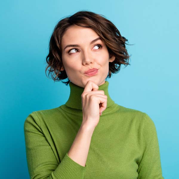 Portrait of minded interested girl touch finger chin look copyspace think thoughts decide decision wear green jumper isolated over blue color background